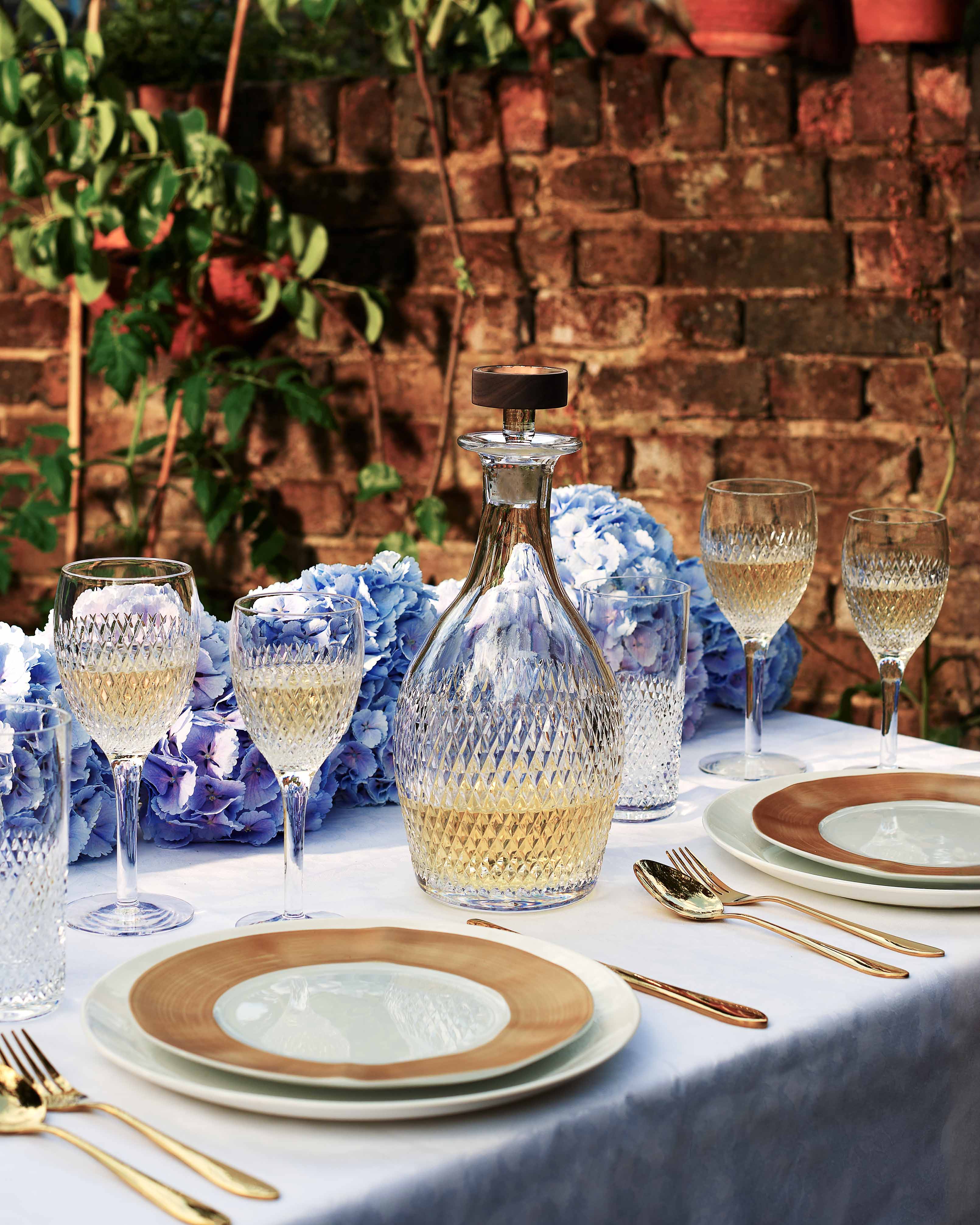 Blue and white tablescape against a brick backdrop