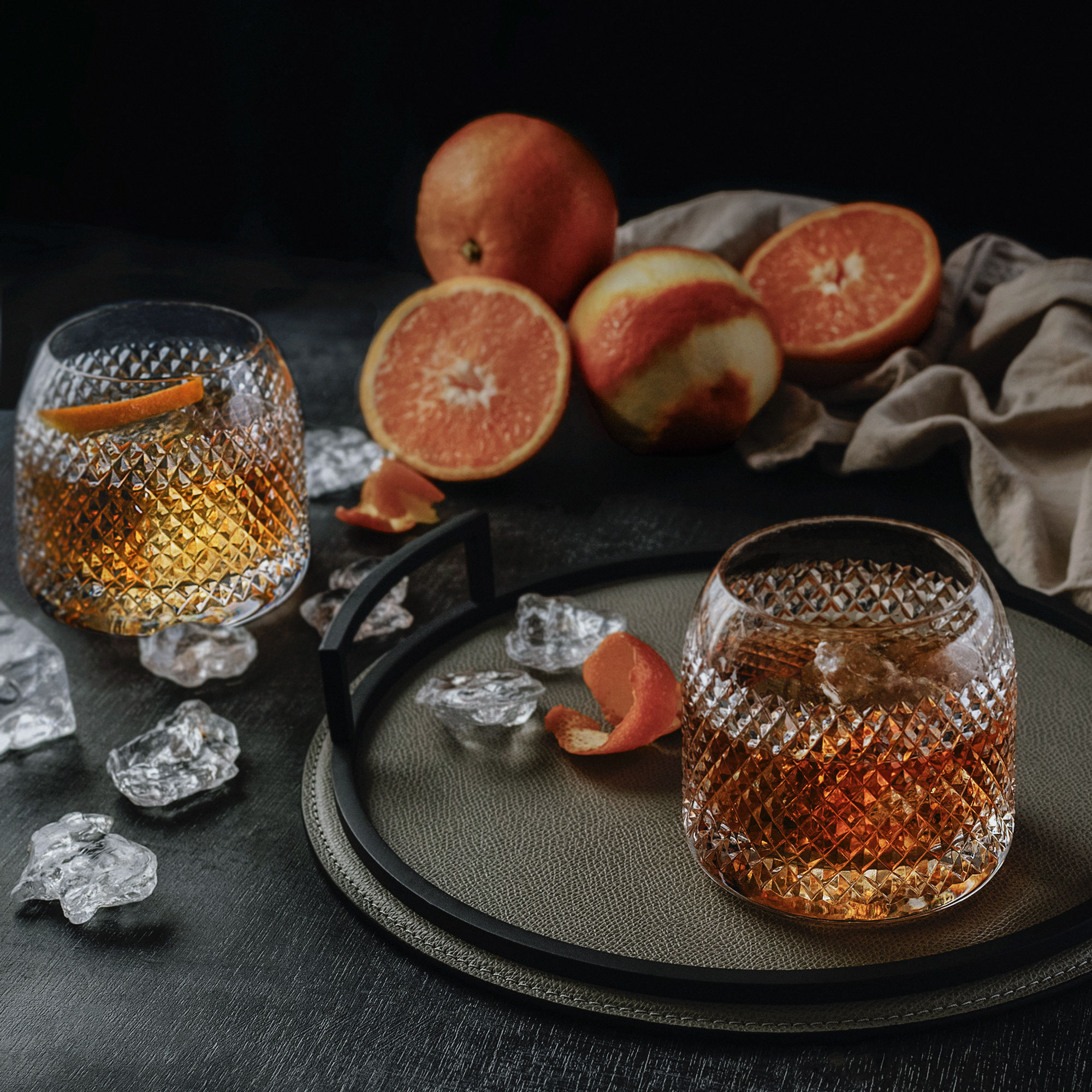 Crystal whisky glass with citrus on a dark background